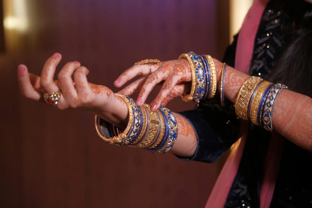 Henna-adorned hands showcasing traditional Indian jewelry and bangles.